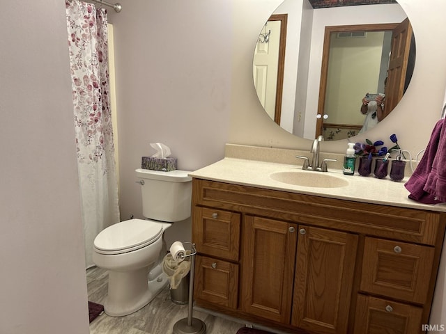 bathroom with hardwood / wood-style floors, vanity, and toilet