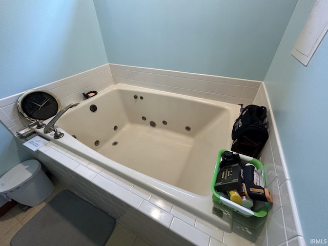 bathroom with tile patterned floors, a relaxing tiled tub, and toilet