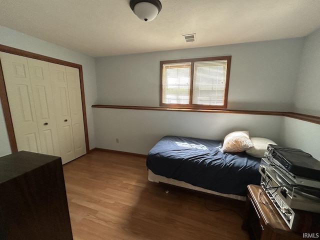 bedroom with hardwood / wood-style floors and a closet