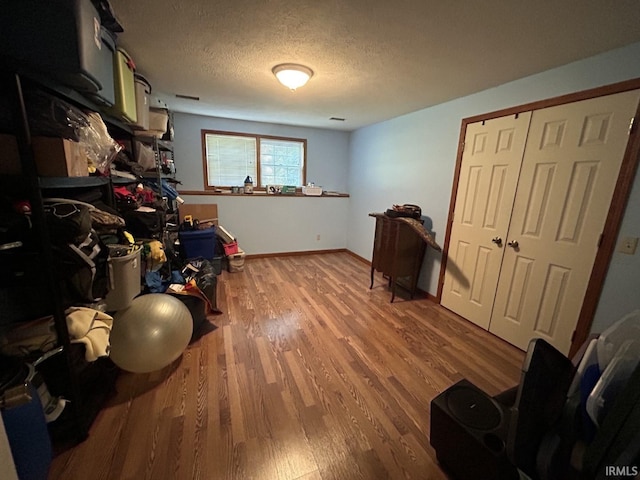 miscellaneous room featuring hardwood / wood-style floors and a textured ceiling