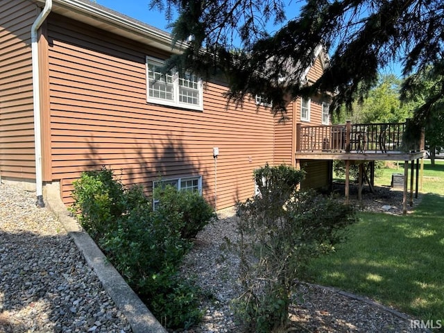 view of side of property featuring a yard and a wooden deck