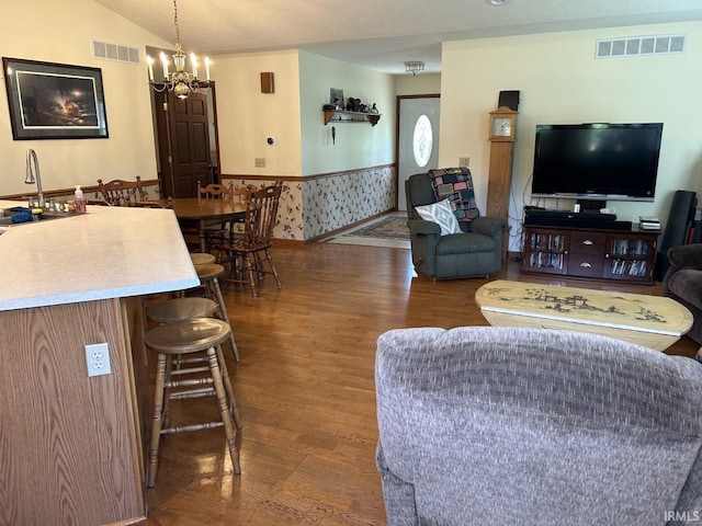 living room featuring dark hardwood / wood-style floors, a notable chandelier, and sink