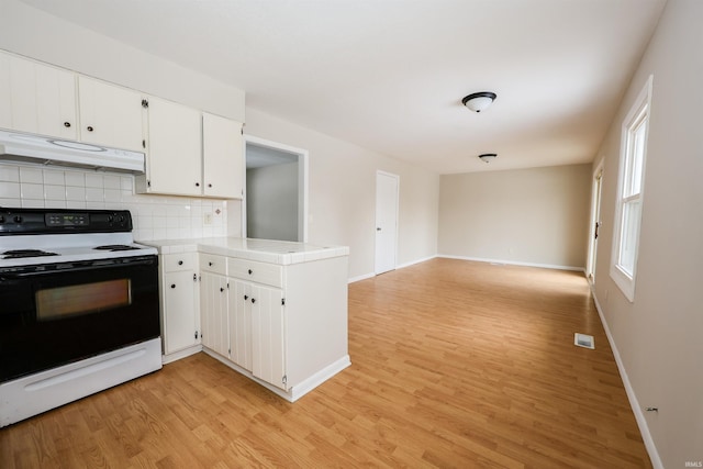 kitchen featuring kitchen peninsula, backsplash, white electric range oven, light hardwood / wood-style floors, and white cabinetry