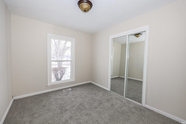 unfurnished bedroom with carpet floors and a closet