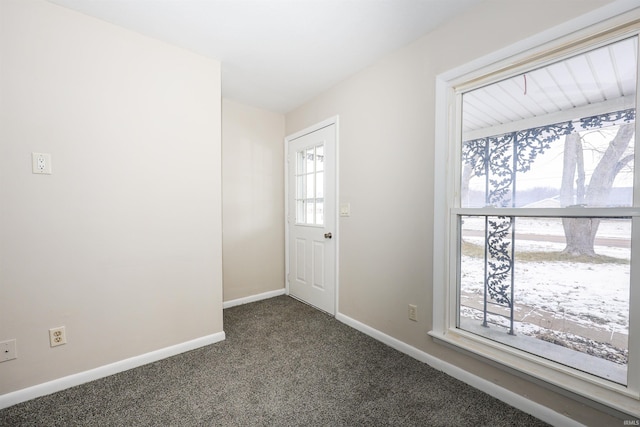 foyer with dark colored carpet and a wealth of natural light