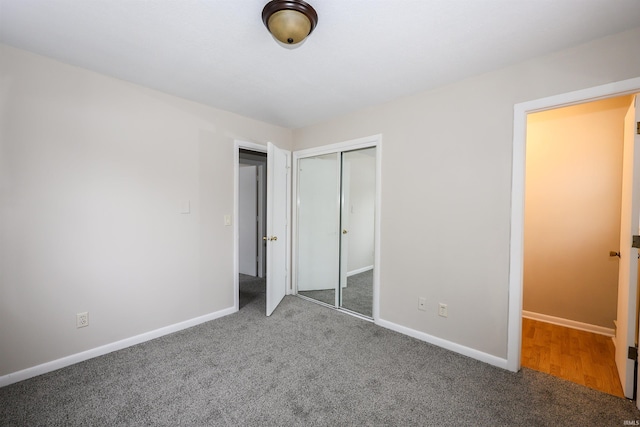 unfurnished bedroom featuring dark colored carpet and a closet