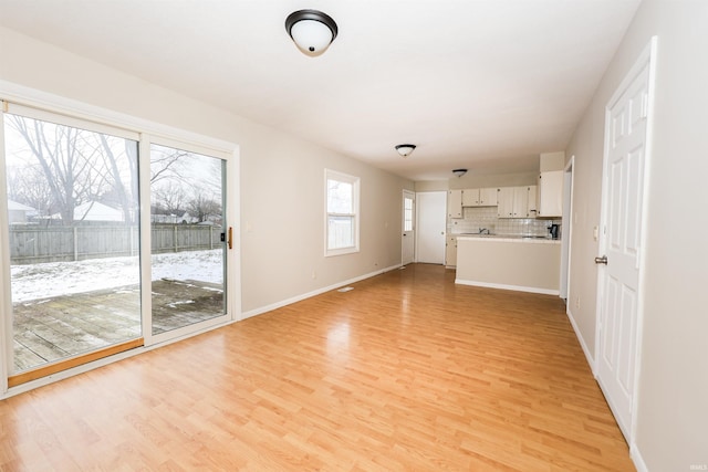 unfurnished living room with light wood-type flooring and a wealth of natural light