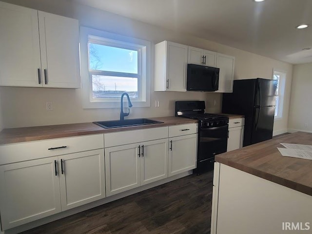 kitchen with black appliances, sink, white cabinets, and wooden counters