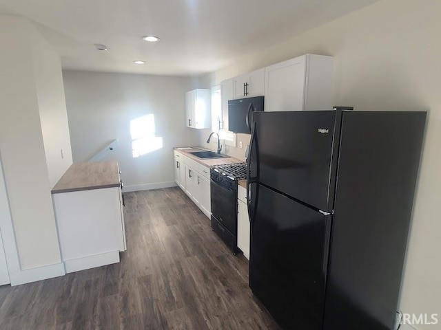 kitchen with black appliances, dark hardwood / wood-style floors, white cabinetry, and sink