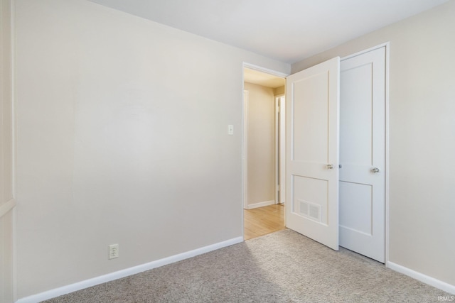 unfurnished bedroom featuring light carpet