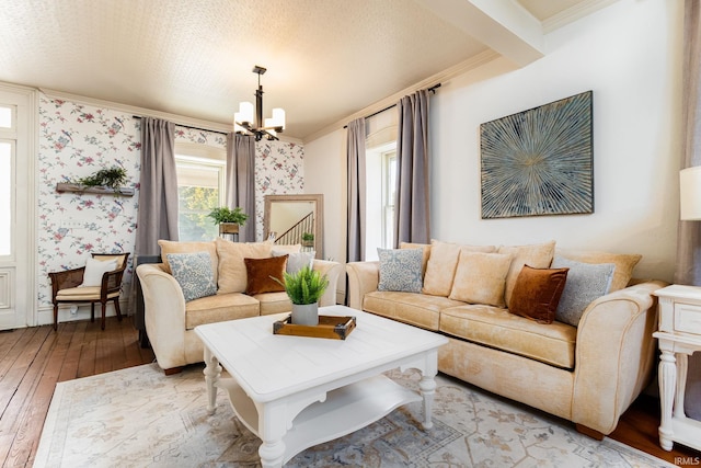 living room with light hardwood / wood-style floors, an inviting chandelier, and ornamental molding