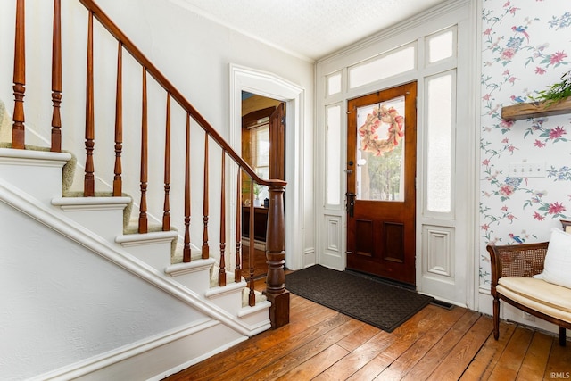 foyer featuring hardwood / wood-style flooring and crown molding