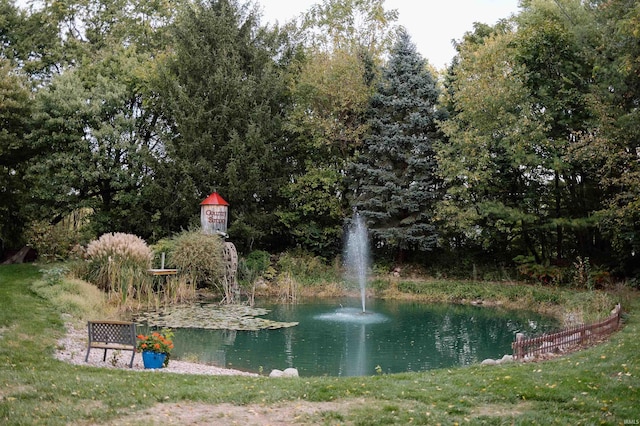 view of community with a lawn and a water view