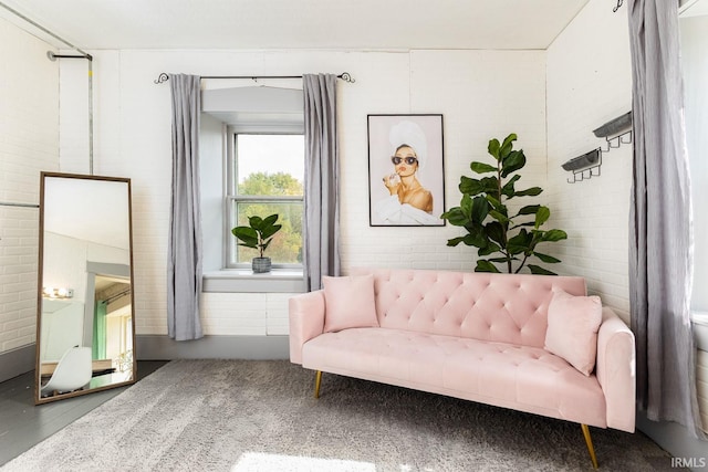 sitting room featuring brick wall