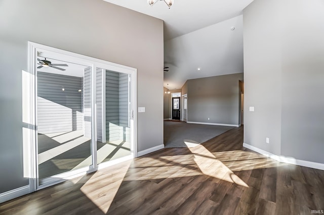 spare room with dark hardwood / wood-style flooring and ceiling fan with notable chandelier