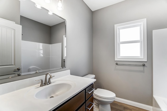 bathroom with hardwood / wood-style floors, vanity, and toilet