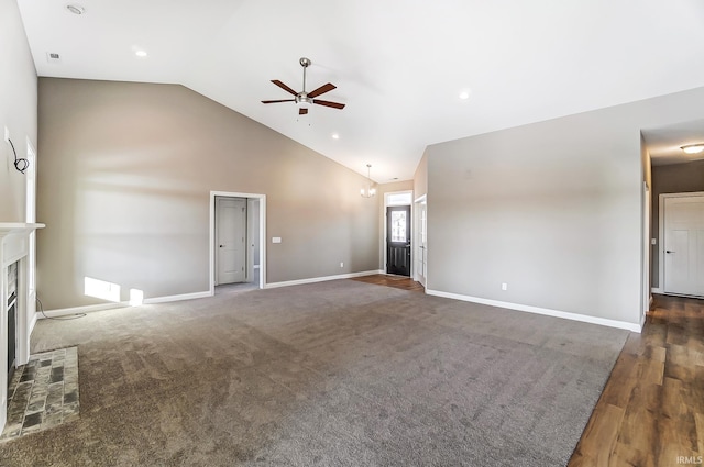 unfurnished living room with a fireplace, ceiling fan with notable chandelier, dark hardwood / wood-style floors, and high vaulted ceiling