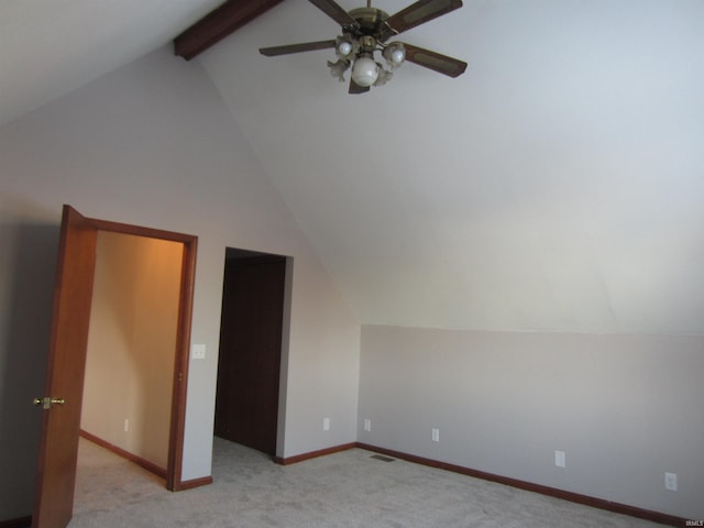 additional living space with vaulted ceiling with beams, ceiling fan, and light colored carpet