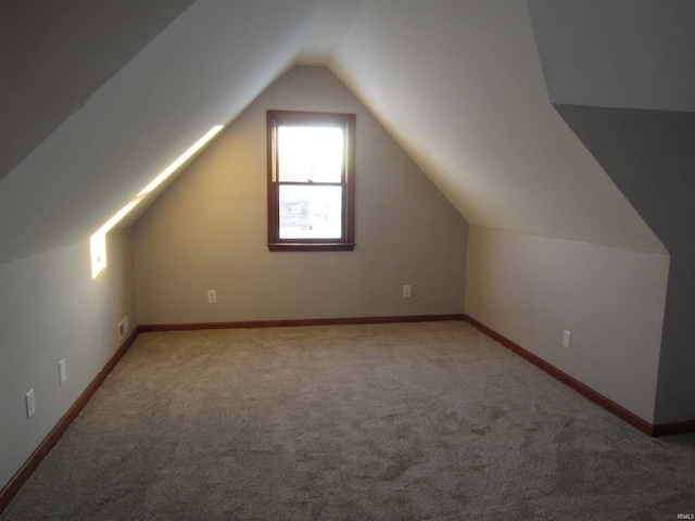 additional living space with carpet flooring and lofted ceiling