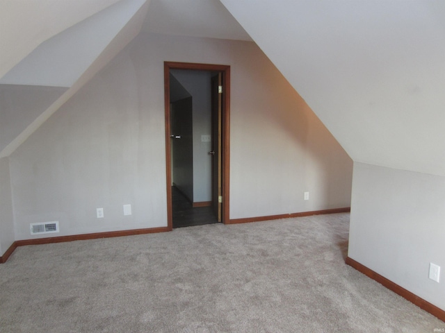 bonus room with light colored carpet and lofted ceiling