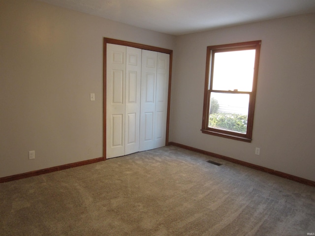 unfurnished bedroom with carpet and a closet