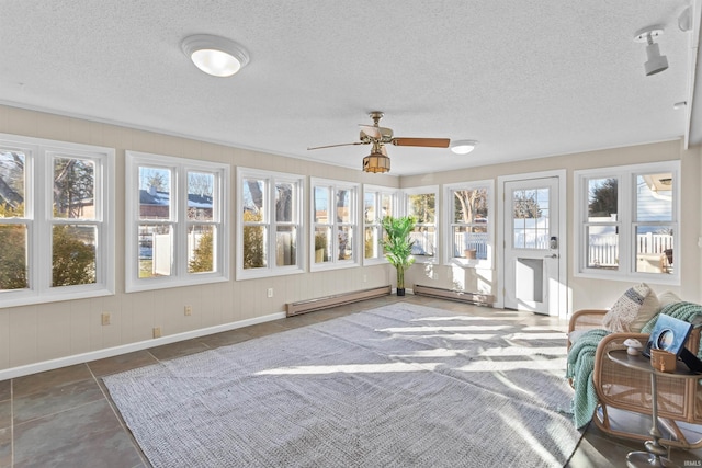 sunroom with a baseboard radiator, ceiling fan, and a healthy amount of sunlight