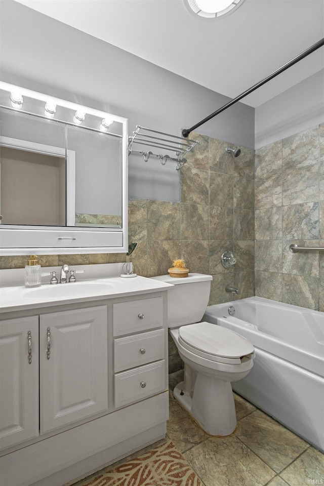 full bathroom with tile patterned floors, tiled shower / bath combo, toilet, and vanity