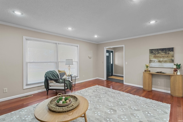 sitting room with hardwood / wood-style flooring, a textured ceiling, and ornamental molding