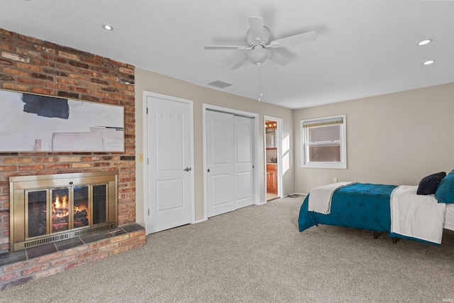 bedroom featuring carpet, a brick fireplace, and ceiling fan