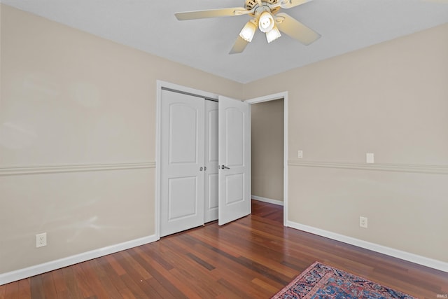 unfurnished bedroom with ceiling fan, dark hardwood / wood-style flooring, and a closet