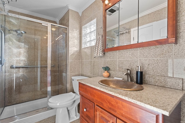 bathroom with vanity, backsplash, crown molding, toilet, and tile walls