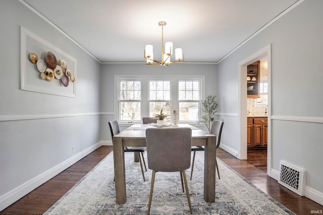 dining area with dark hardwood / wood-style flooring, a chandelier, and ornamental molding