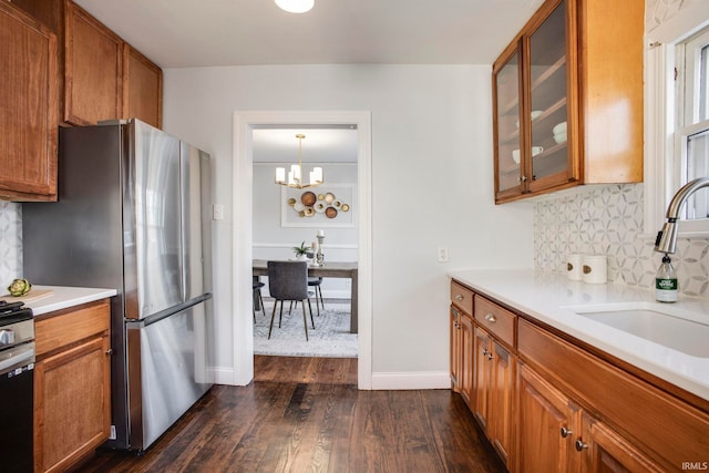 kitchen with sink, hanging light fixtures, dark hardwood / wood-style floors, appliances with stainless steel finishes, and a chandelier