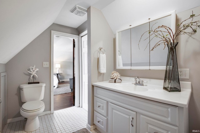 bathroom featuring tile patterned flooring, vanity, toilet, and lofted ceiling