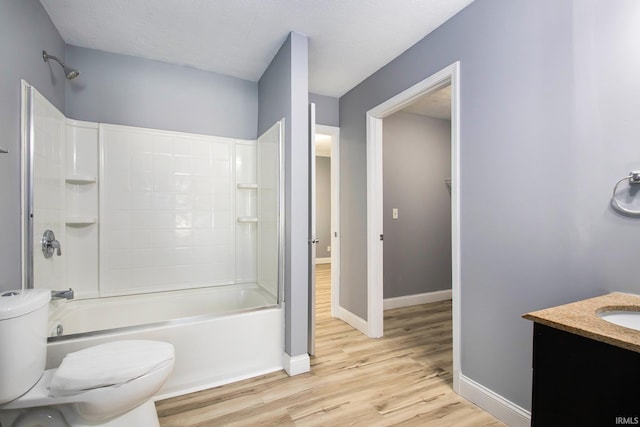 full bathroom with vanity, a textured ceiling, shower / bathing tub combination, hardwood / wood-style flooring, and toilet