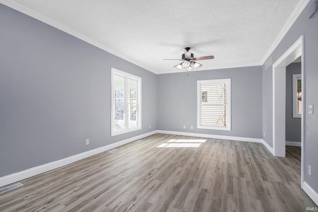 empty room featuring a textured ceiling, ceiling fan, light hardwood / wood-style floors, and crown molding