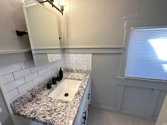 bathroom with vanity and decorative backsplash