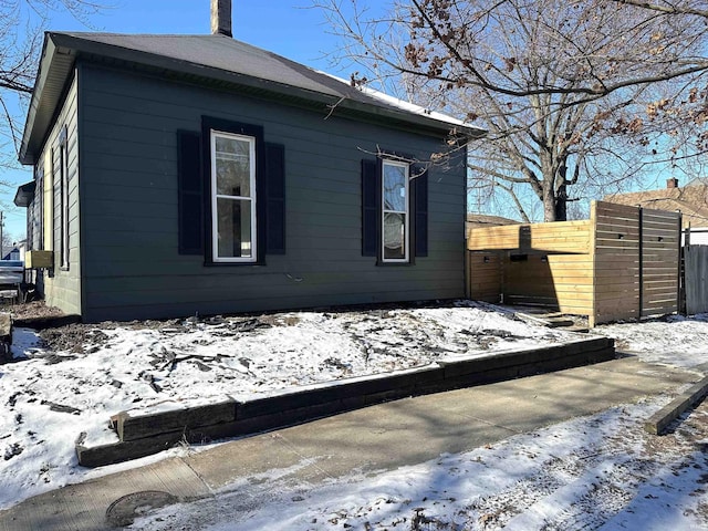 view of snow covered exterior featuring fence