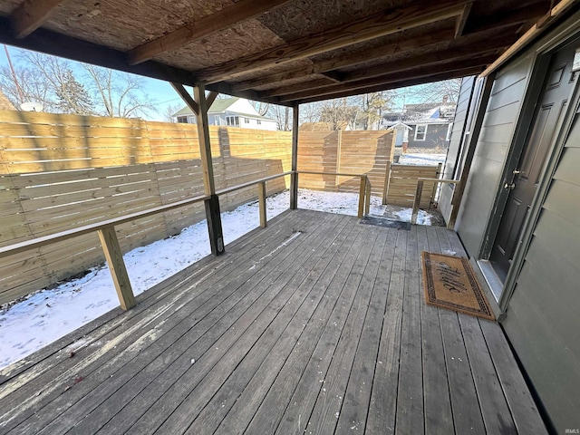 snow covered deck featuring a fenced backyard