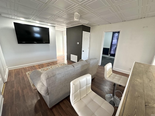 living room featuring an ornate ceiling, baseboards, and dark wood-type flooring