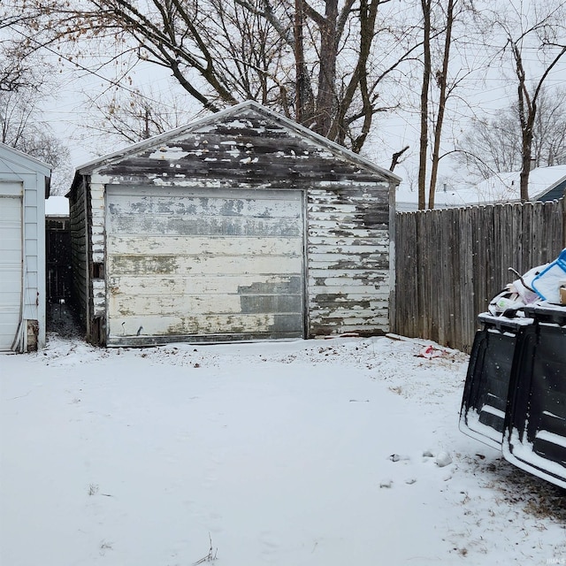 snow covered structure with a garage