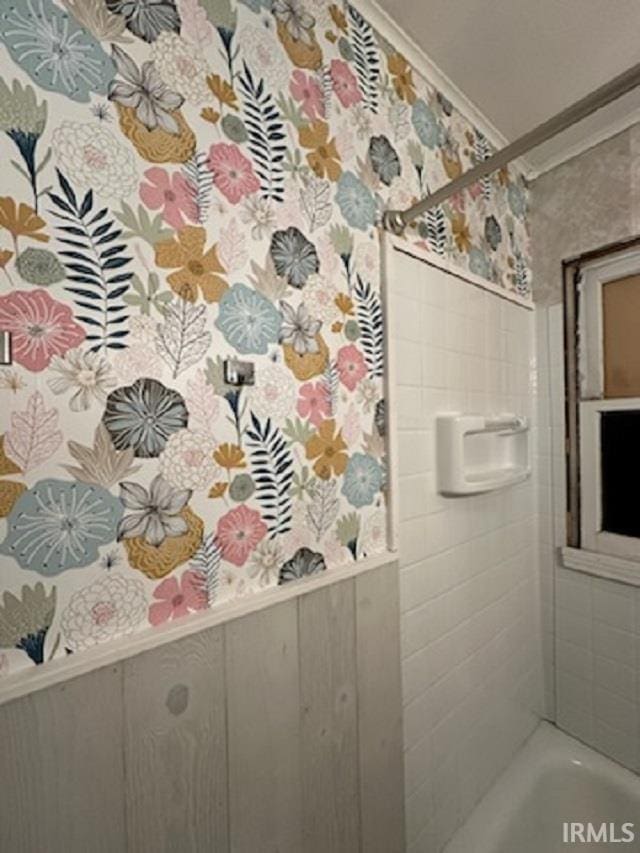 bathroom featuring wood walls, ornamental molding, and bathtub / shower combination