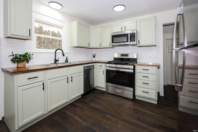 kitchen with butcher block counters, sink, dark hardwood / wood-style floors, white cabinets, and appliances with stainless steel finishes