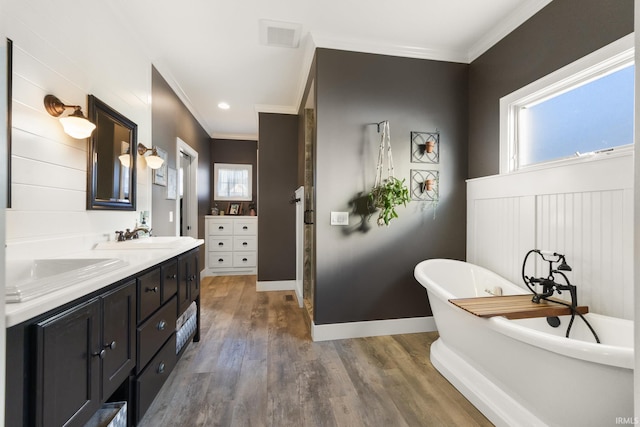 bathroom with plenty of natural light, vanity, a bath, and ornamental molding