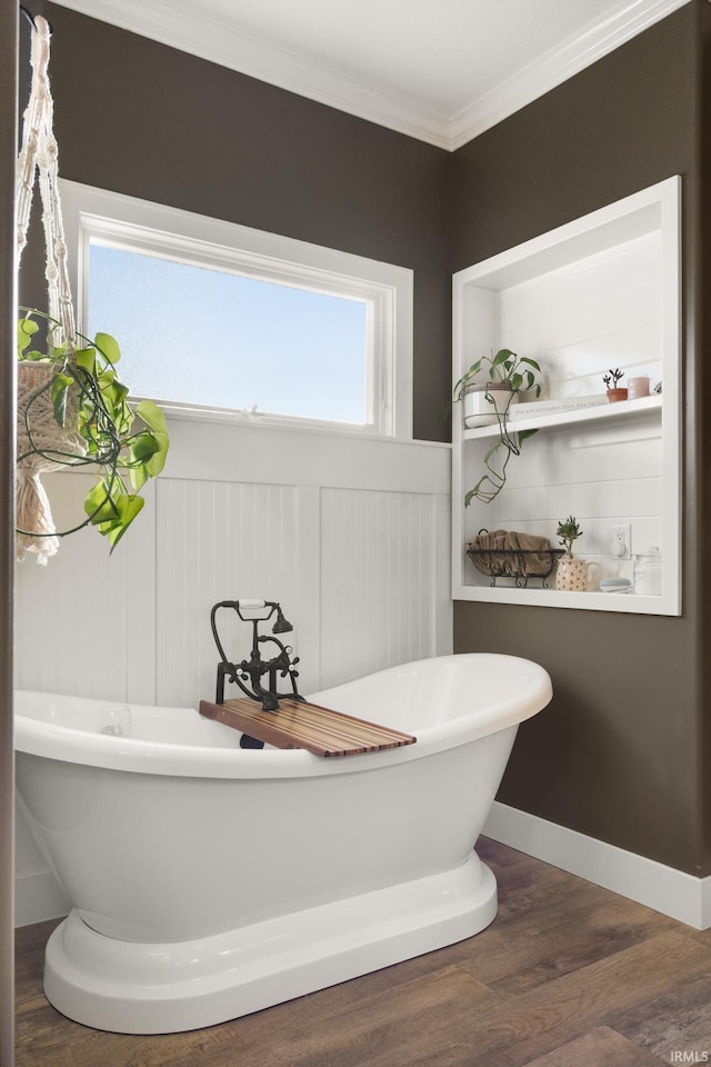 bathroom with crown molding, wood-type flooring, and a bath