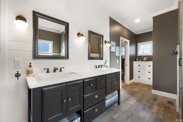 bathroom with hardwood / wood-style floors, vanity, and crown molding