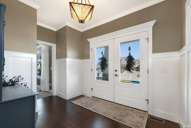 foyer entrance featuring plenty of natural light, dark hardwood / wood-style flooring, ornamental molding, and french doors