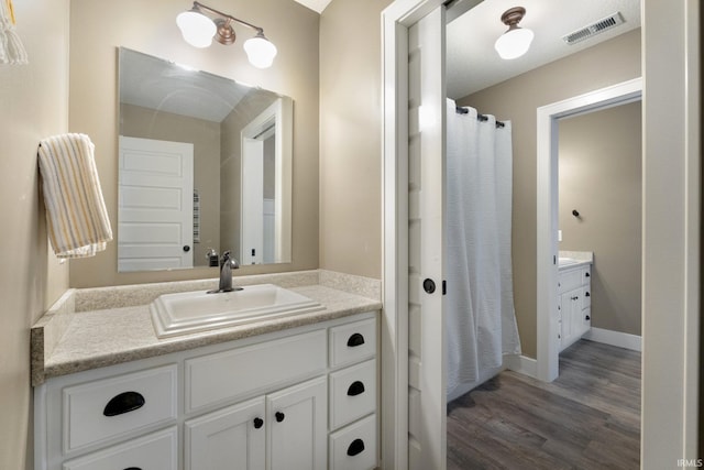 bathroom featuring a shower with curtain, vanity, and wood-type flooring