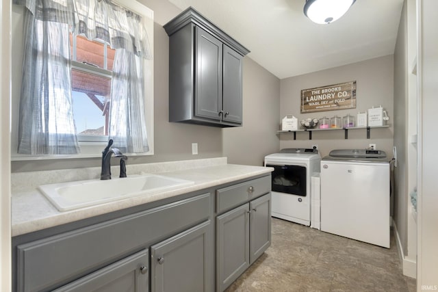 clothes washing area with cabinets, washing machine and dryer, and sink