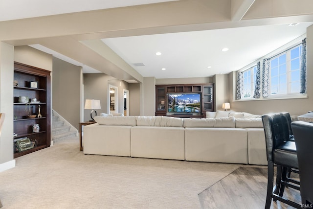 living room with built in shelves and light hardwood / wood-style flooring